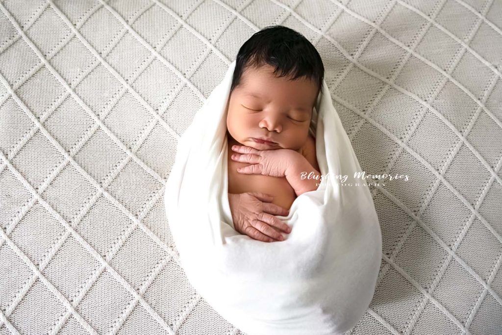 newborn baby boy photo session wrapped in a wrap for studio portrait