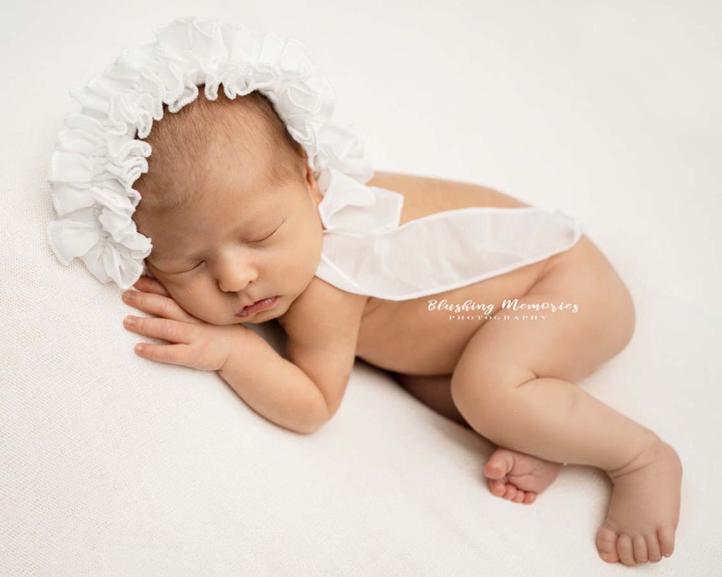 newborn baby girl in lying position for a posed newborn photo session