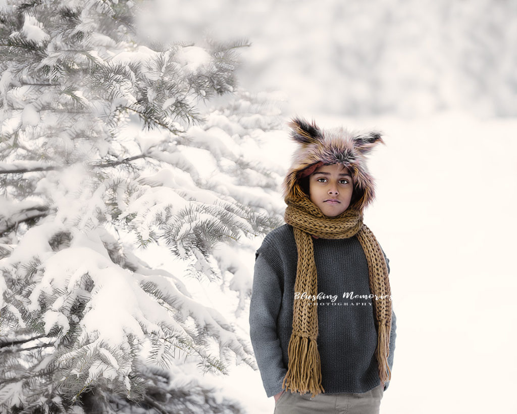 Winter photo Portrait of a Boy with snow on on trees.