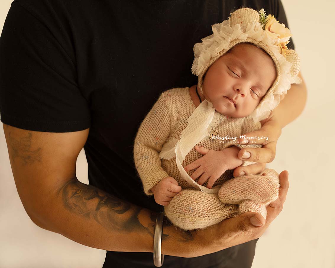 newborn baby girl in her dads hand for the studio photo session