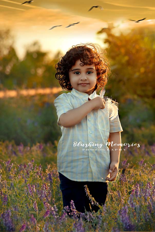 outdoor photo portrait of a boy holding a feather to his chest