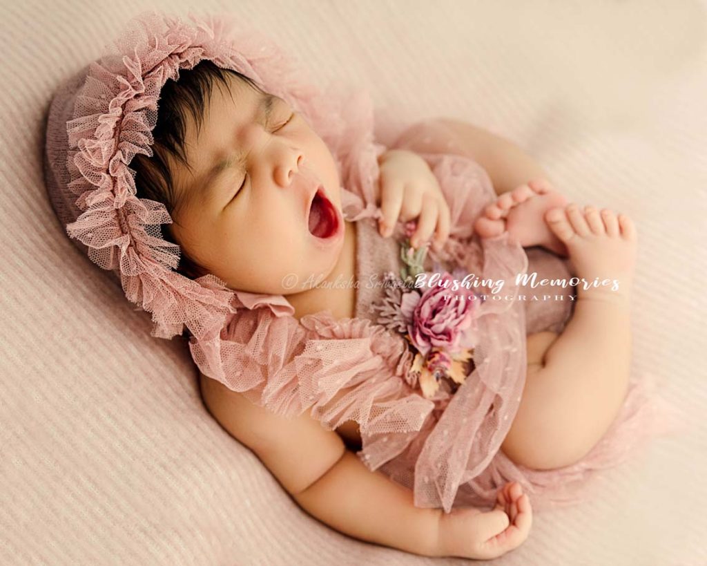 newborn baby girl photo session in sleeping/yawn position