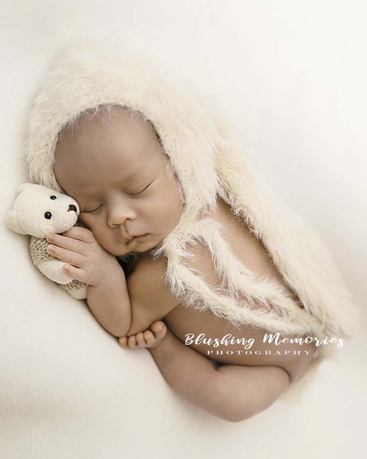 newborn baby boy posed studio photoshoot holding a bunny