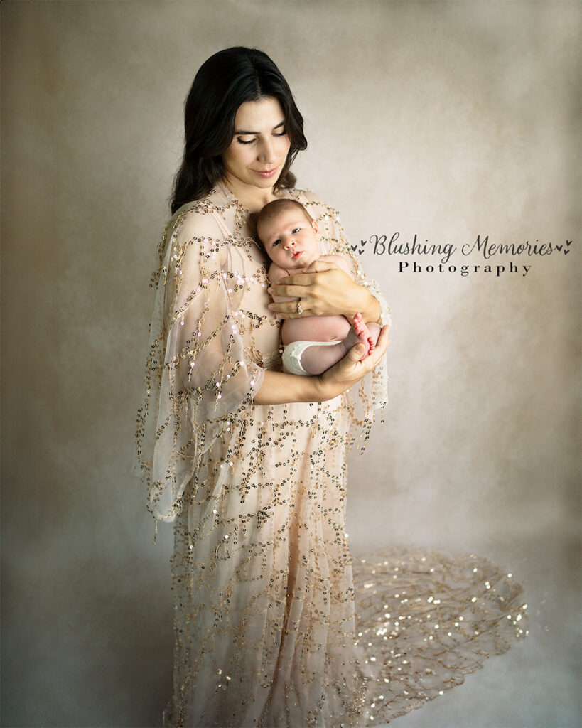 Mother holding newborn baby boy, dressed in a gold sequin gown at Blushing Memories Studio – El Dorado Hills newborn and family photographer