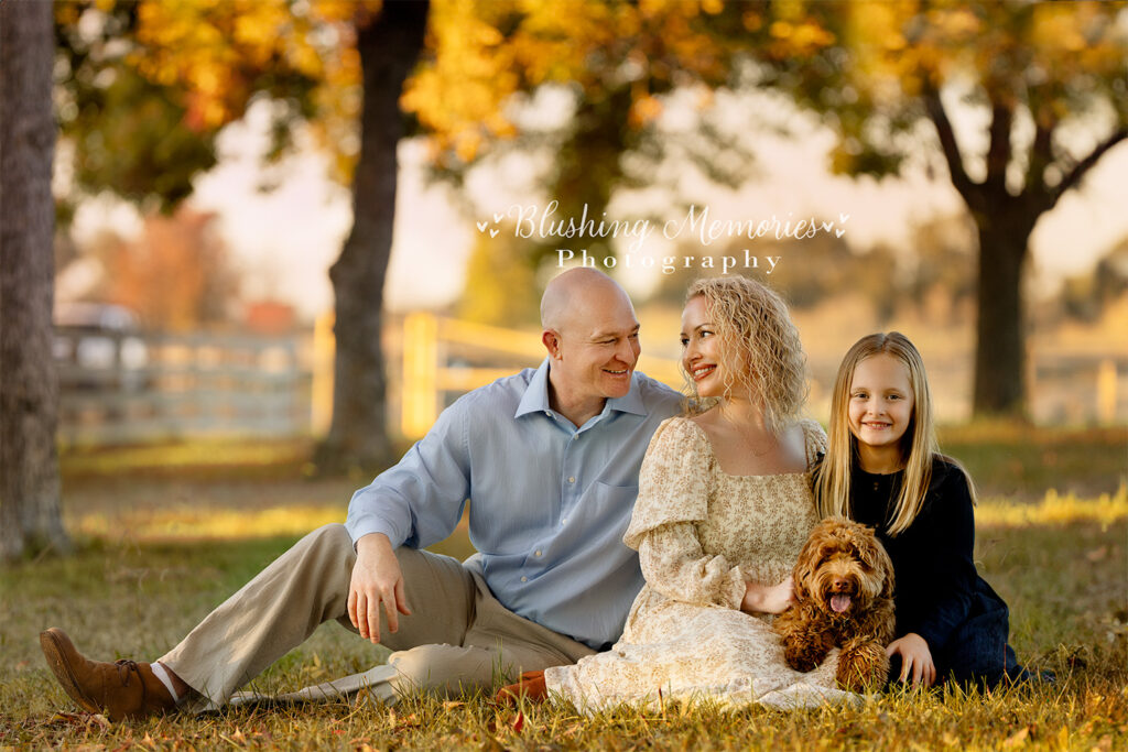 A loving family enjoying a fall outdoor photo session with their daughter and dog, captured by Blushing Memories Photography in Folsom, California.