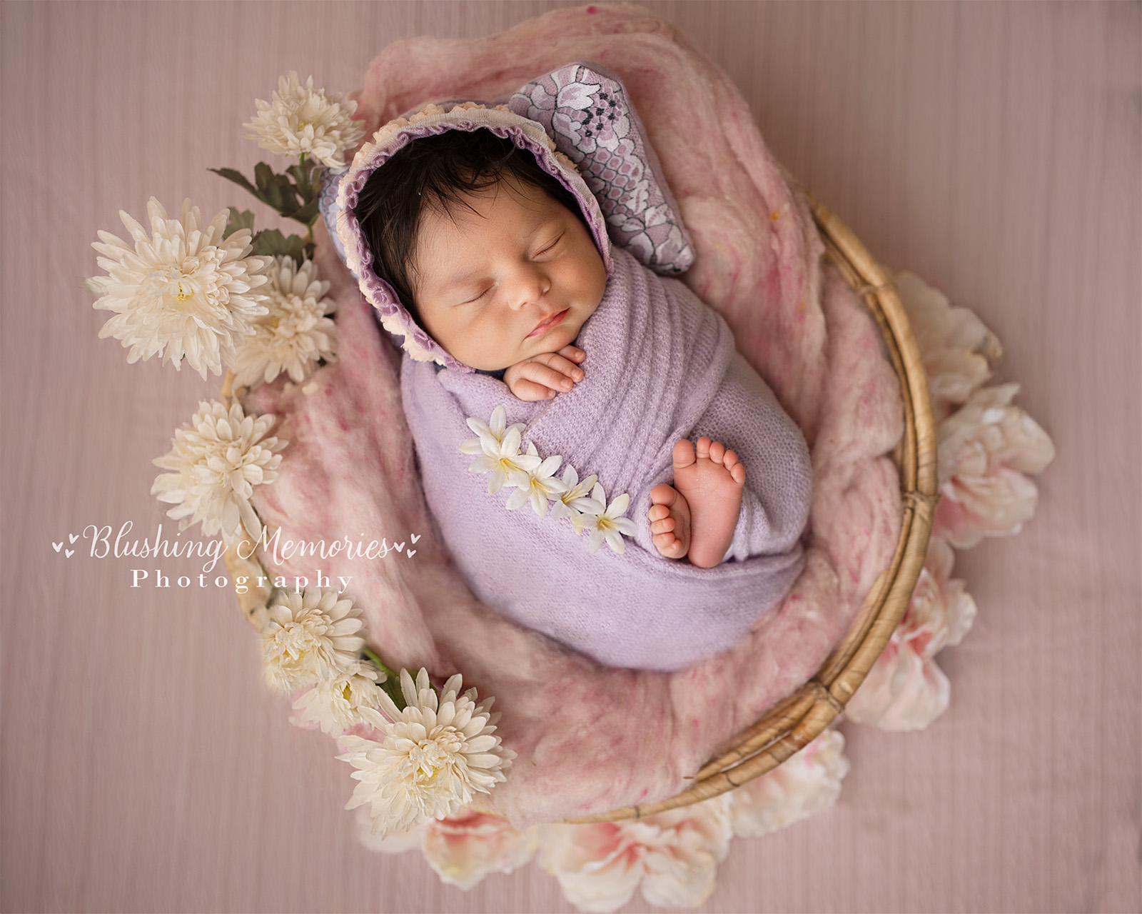 newborn baby girl wrapped in purple wrap in round bowl with white flowers, folsom blushing memories